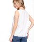 Woman wearing a white sleeveless top and blue jeans on a white background