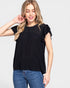 Woman wearing a black top with lace details and blue jeans on a white background