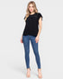 Woman wearing a black top and blue jeans on a white background
