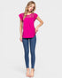 Woman wearing a bright pink top and blue jeans on a white background