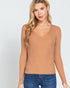 Woman wearing a tan ribbed long-sleeve top against a white background