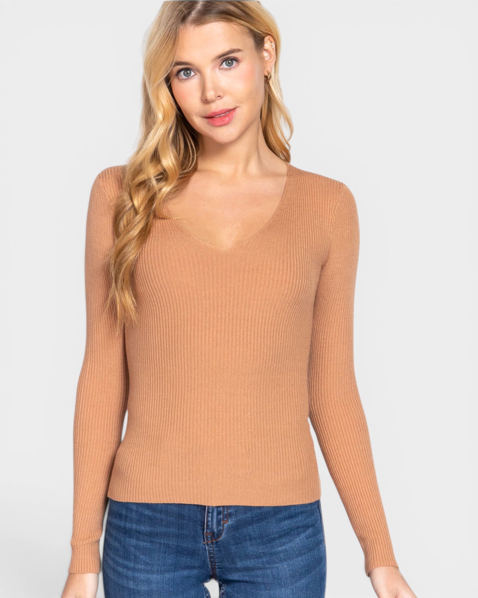 Woman wearing a tan ribbed tank top against a white background