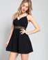 Woman wearing a black dress with lace detail on a gray background