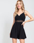 Woman wearing a black dress with lace detail on a white background