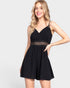 Woman wearing a black romper with lace details on a white background