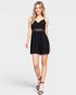 Woman wearing a black romper with lace details on a white background