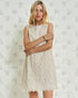 Woman wearing a white lace dress against a textured white background