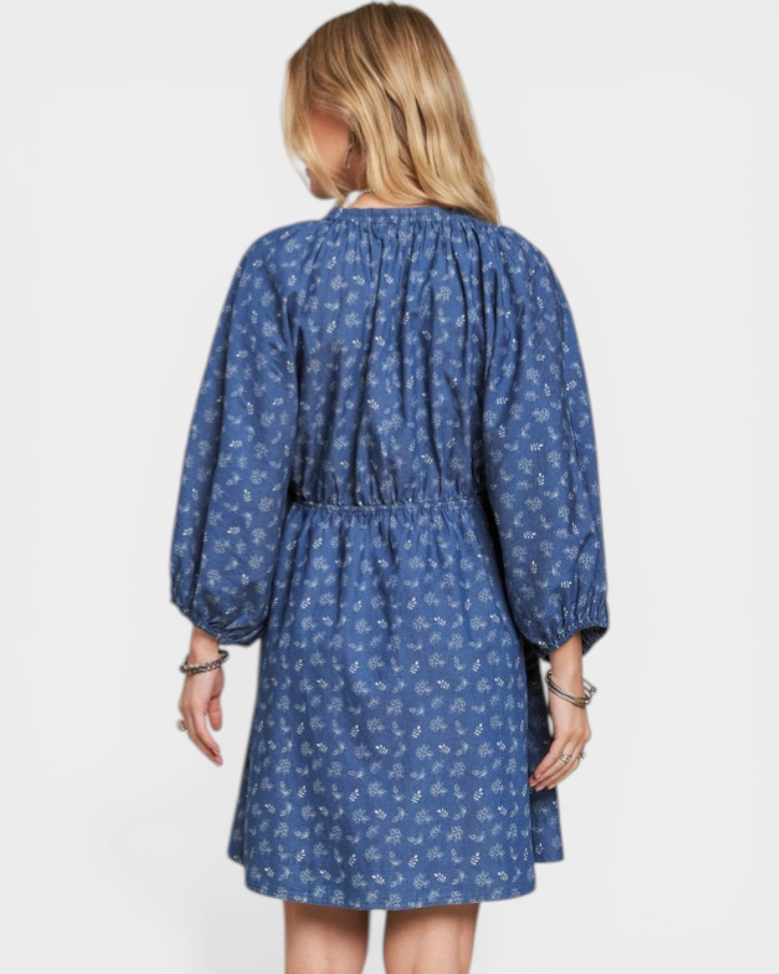 Woman wearing a blue floral dress on a white background