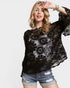 Woman wearing a black lace top and denim shorts on a white background
