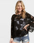 Woman wearing a black lace top with a plain background
