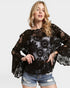 Woman wearing a black lace top and denim shorts on a white background