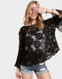Woman wearing a black lace top and denim shorts on a plain background