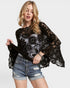 Woman wearing a black lace top and denim shorts on a white background