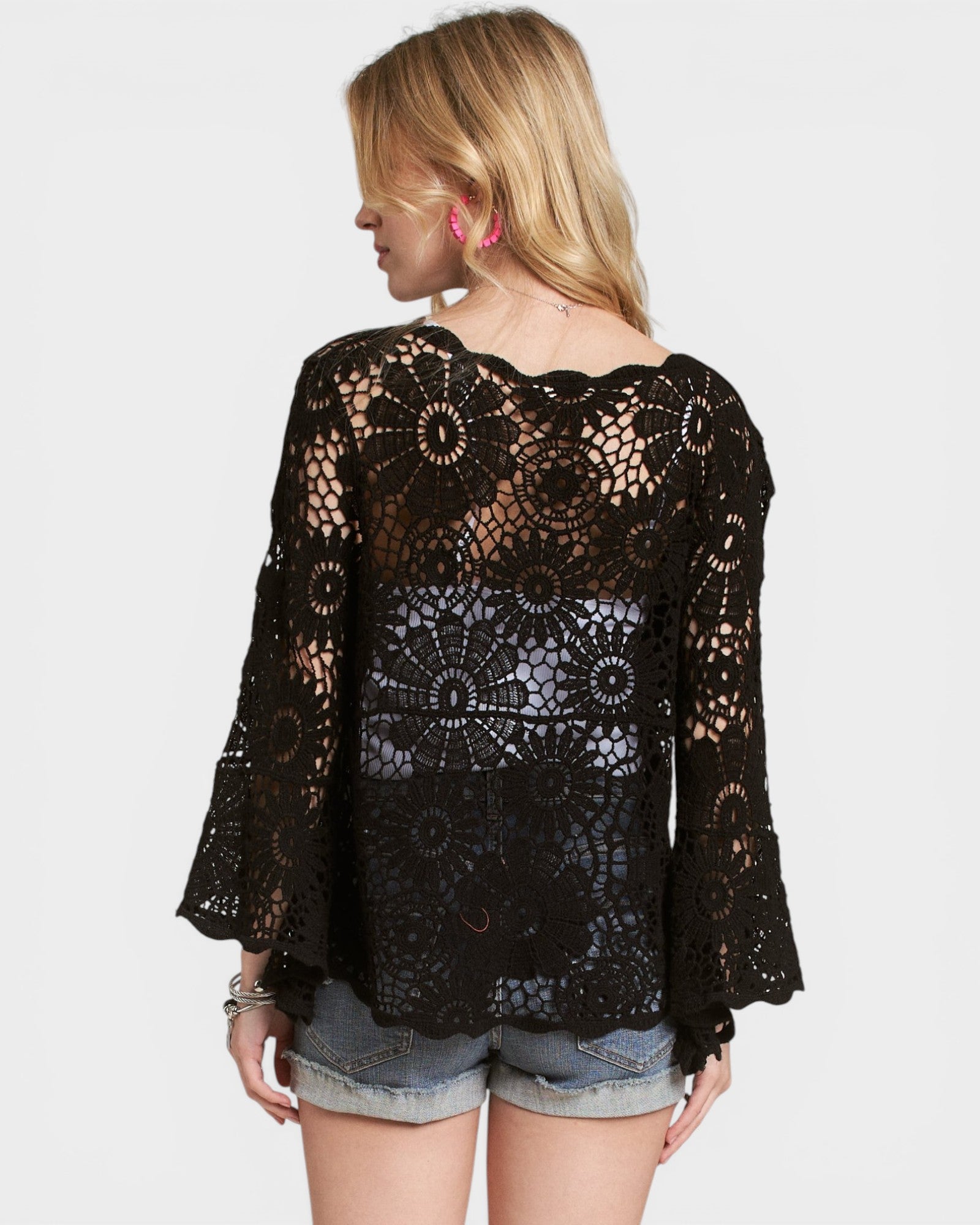 Black lace top worn by a person on a white background