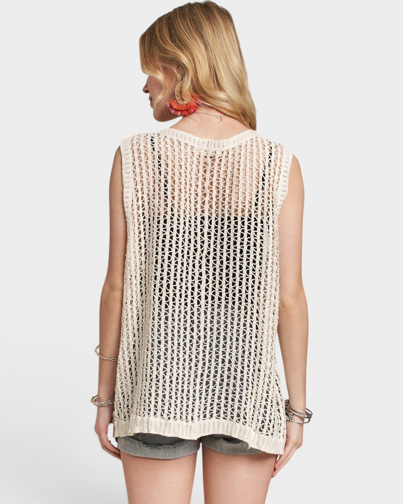 Woman wearing a beige crochet top on a white background
