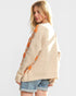 Woman wearing a beige sweater with orange pattern on a white background