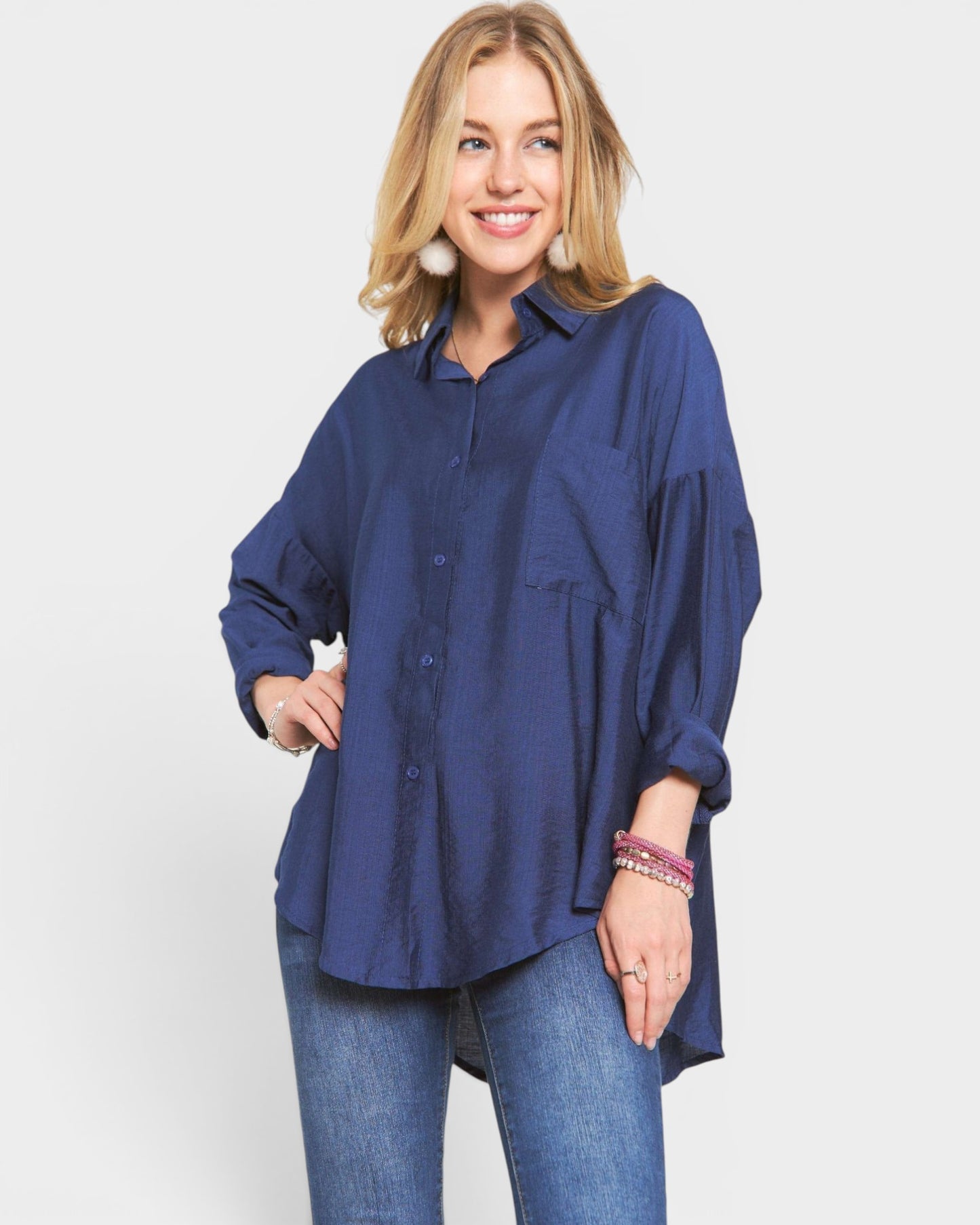 Woman wearing a blue oversized shirt and jeans on a white background
