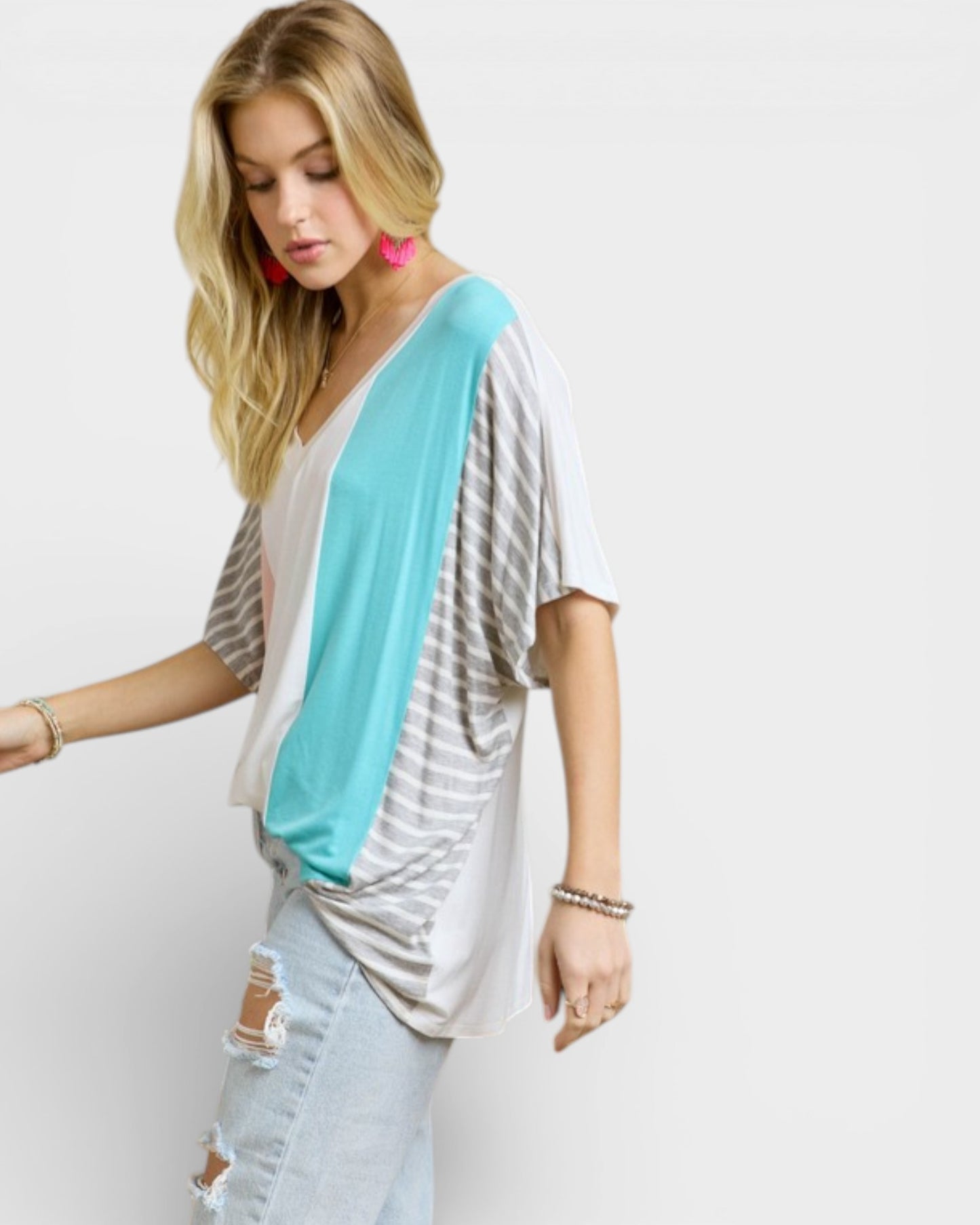 Woman wearing a light blue and gray striped top with a white background