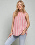 Woman wearing a pink striped sleeveless top and light blue jeans against a gray background