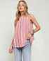 Woman wearing a pink and white striped sleeveless top with light blue jeans on a plain background