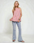 Woman wearing a pink striped top and light blue jeans on a white background