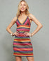 Woman wearing a colorful striped dress against a gray background