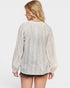 Woman wearing a sheer white blouse with long sleeves on a white background