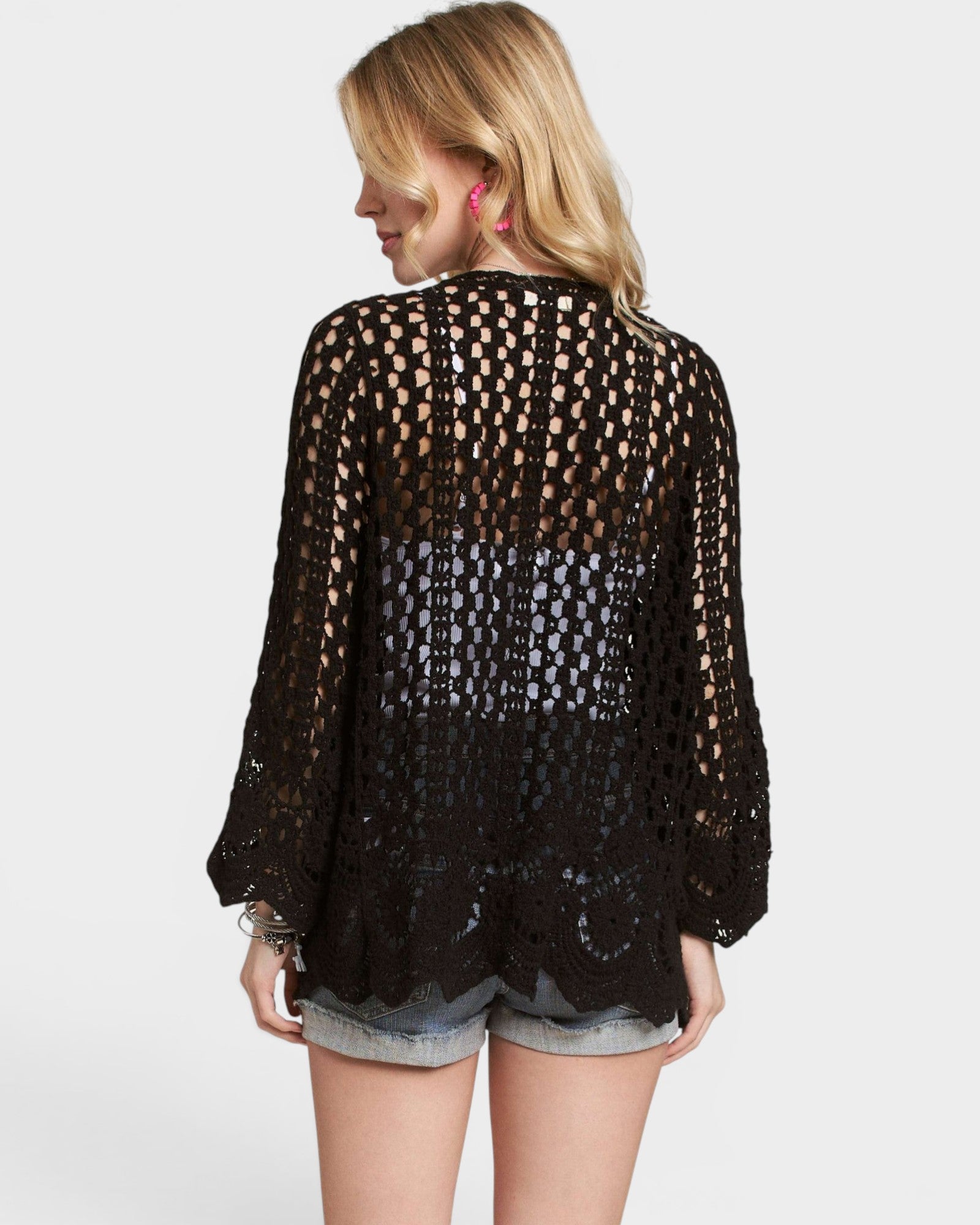 Woman wearing a black crochet top on a white background