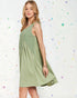 Woman wearing a green dress against a colorful polka dot background