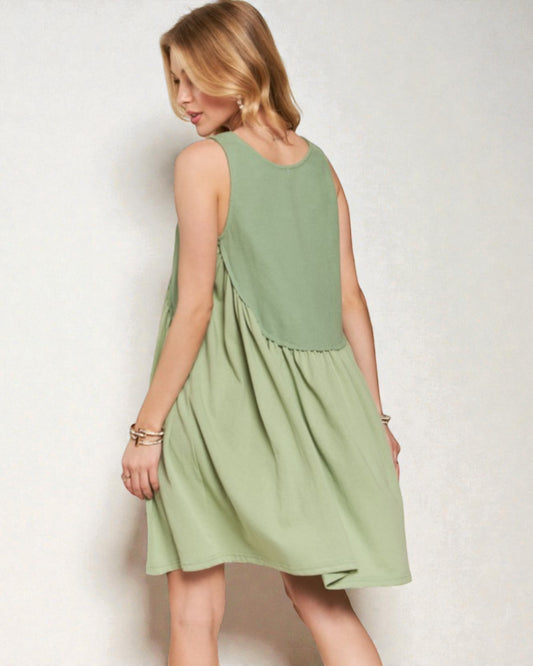 Woman wearing a light green dress against a plain background