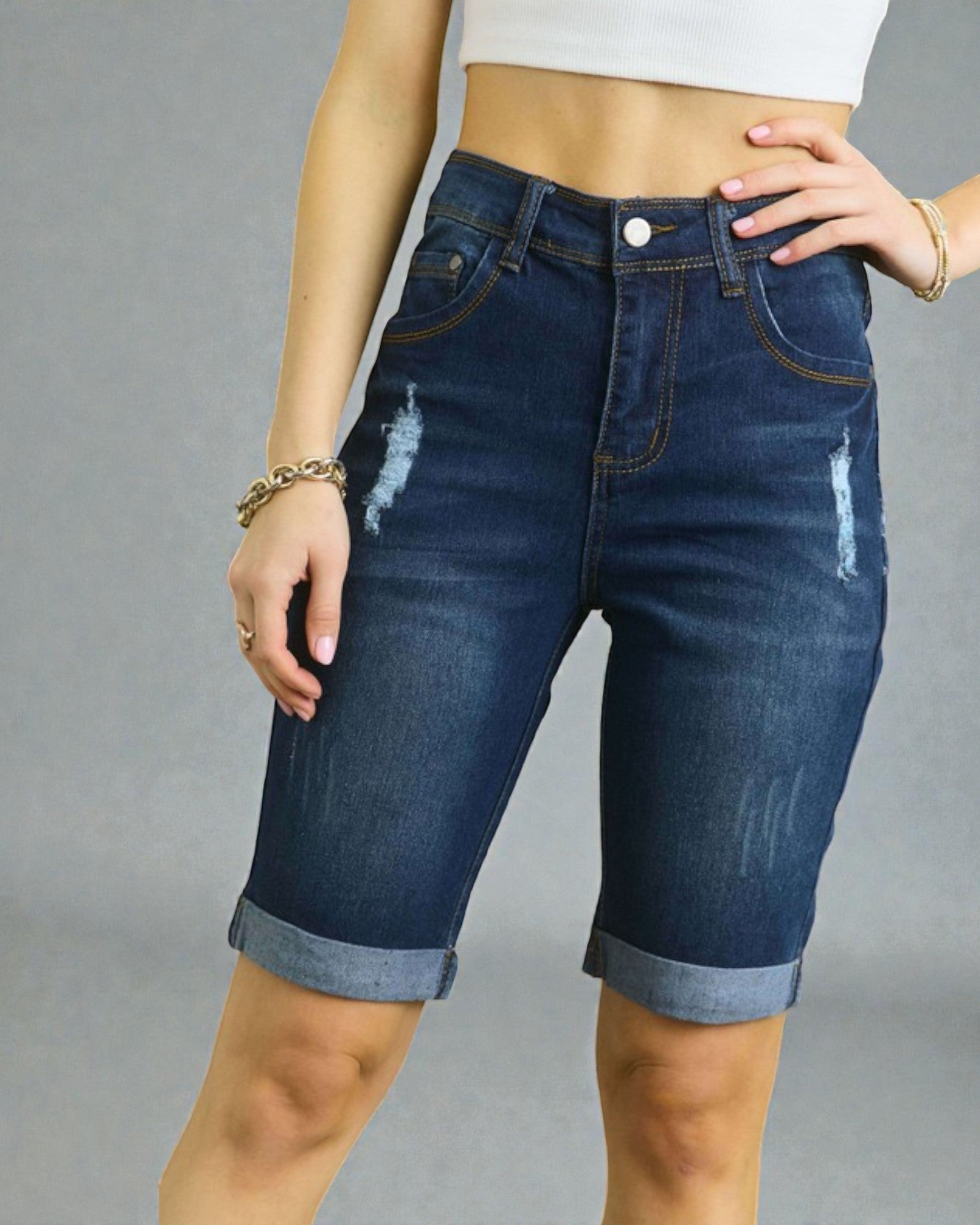 Person wearing blue denim shorts on a gray background