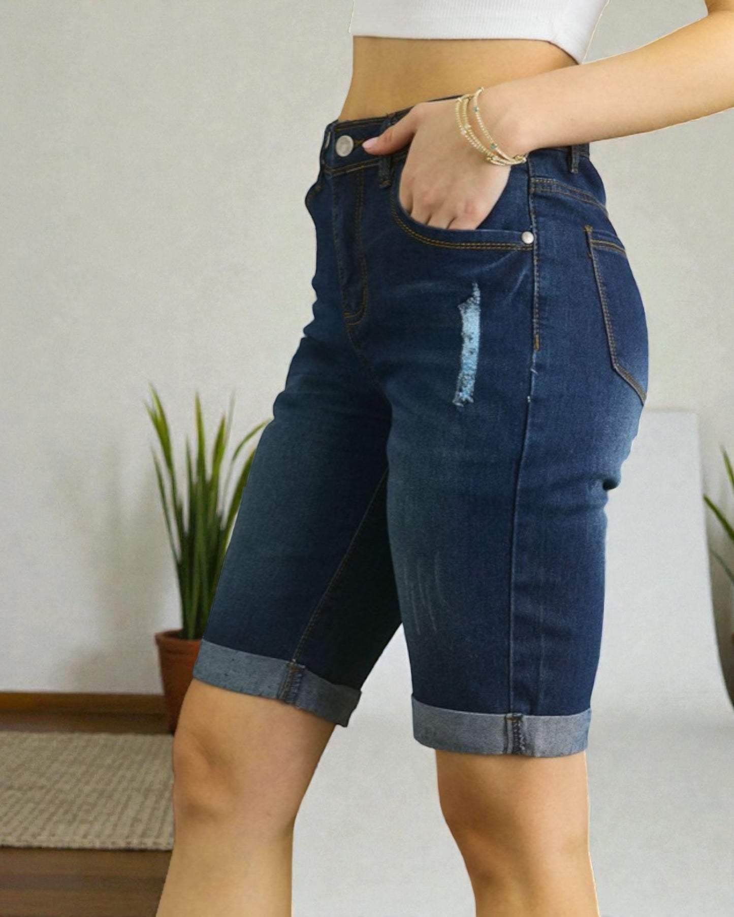 Person wearing blue denim shorts with a neutral background