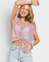 Woman wearing a pink crochet top and light blue jeans against a white background