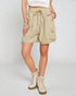 Person wearing beige shorts and white boots on a plain background