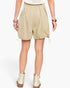 A model from the back wearing beige high-waisted drawstring shorts, a white knit top, and off-white platform ankle boots against a light gray studio background.
