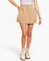 A model wearing a beige utility-style mini skirt with side pockets and a drawstring waist, paired with beige lace-up ankle boots, against a plain white studio background.
