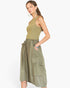 A woman modeling a sleeveless olive green top and matching olive green high-waisted cargo skirt against a plain white background.
