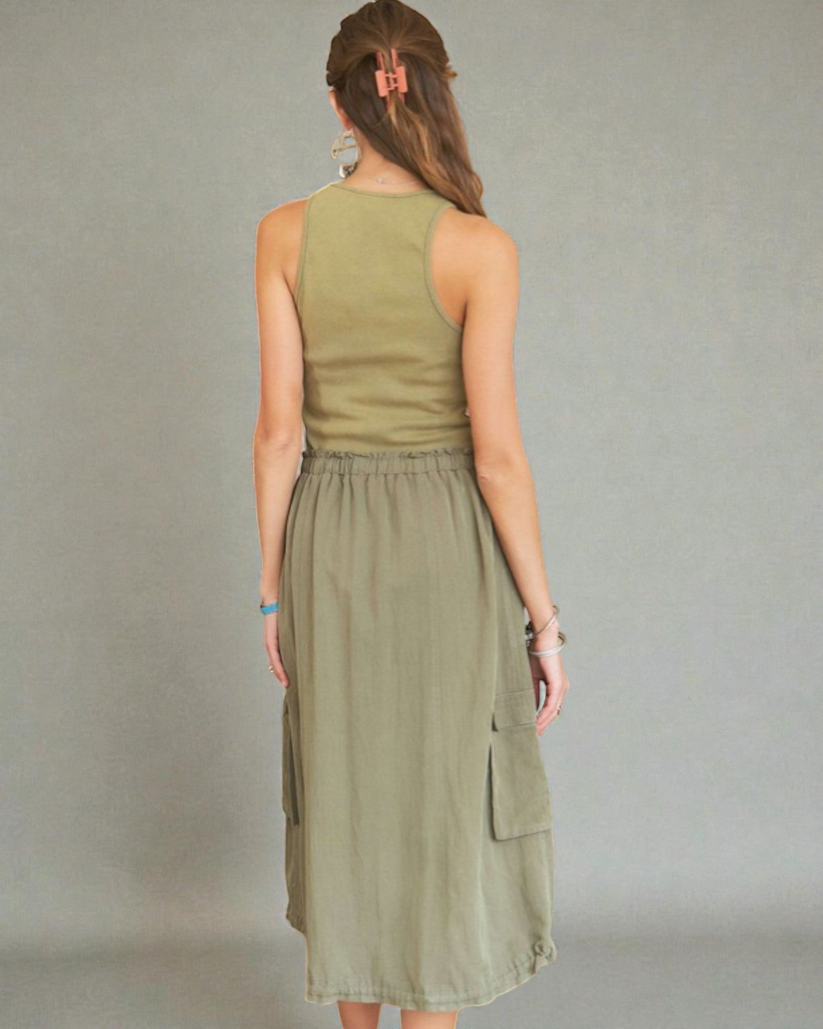 Woman wearing an olive green dress against a gray background