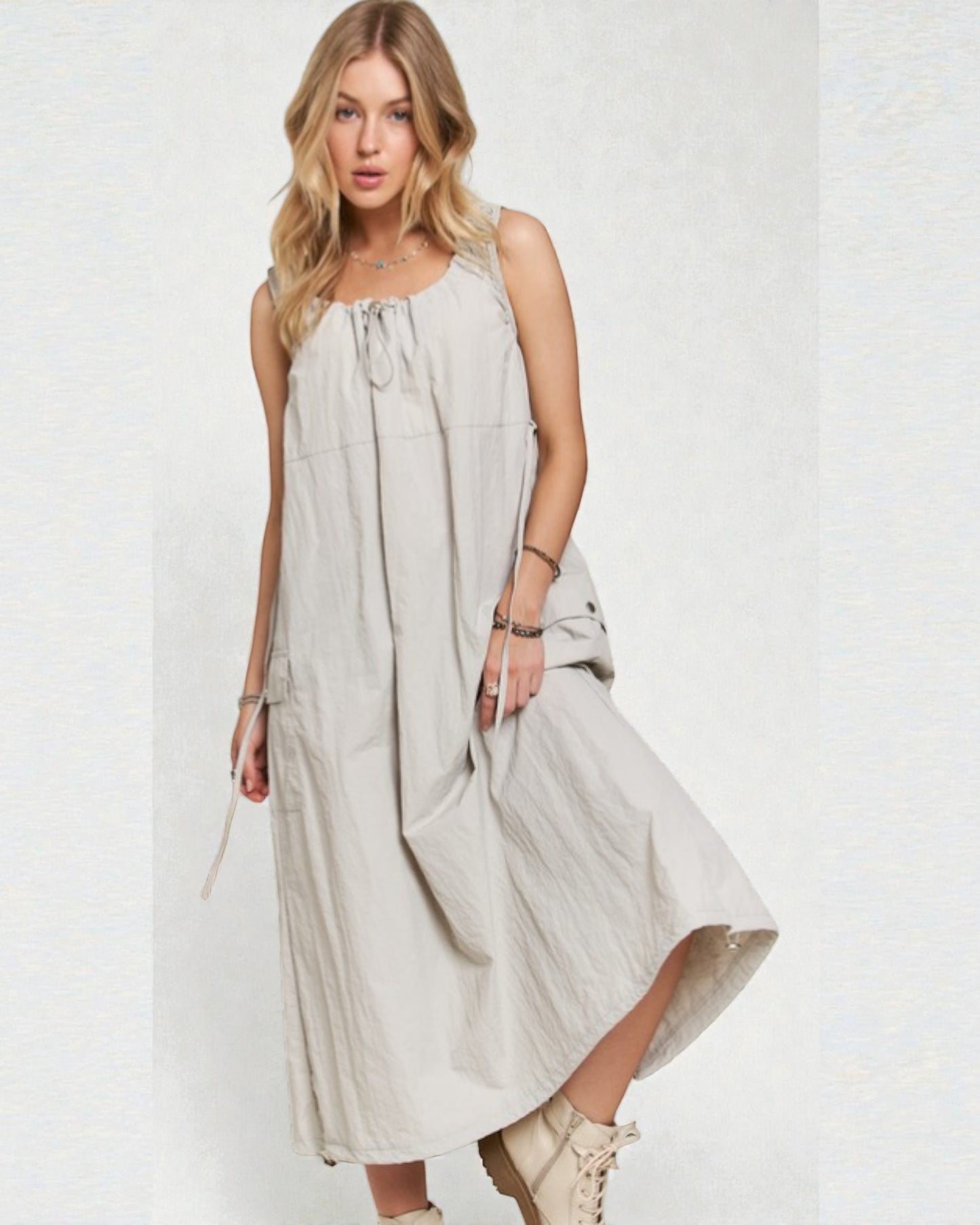 Woman wearing a light gray sleeveless dress on a white background