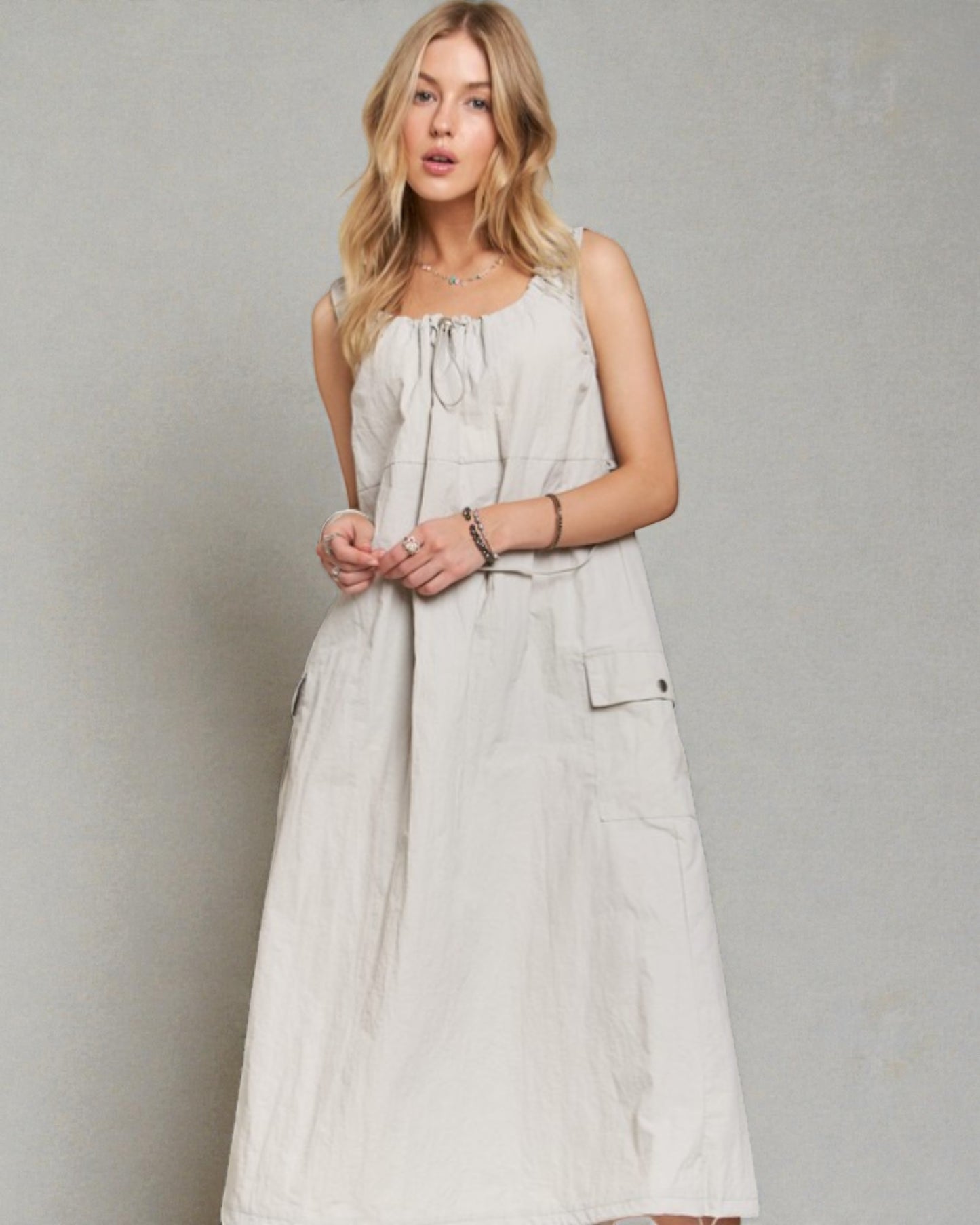 Woman wearing a light-colored dress against a plain background