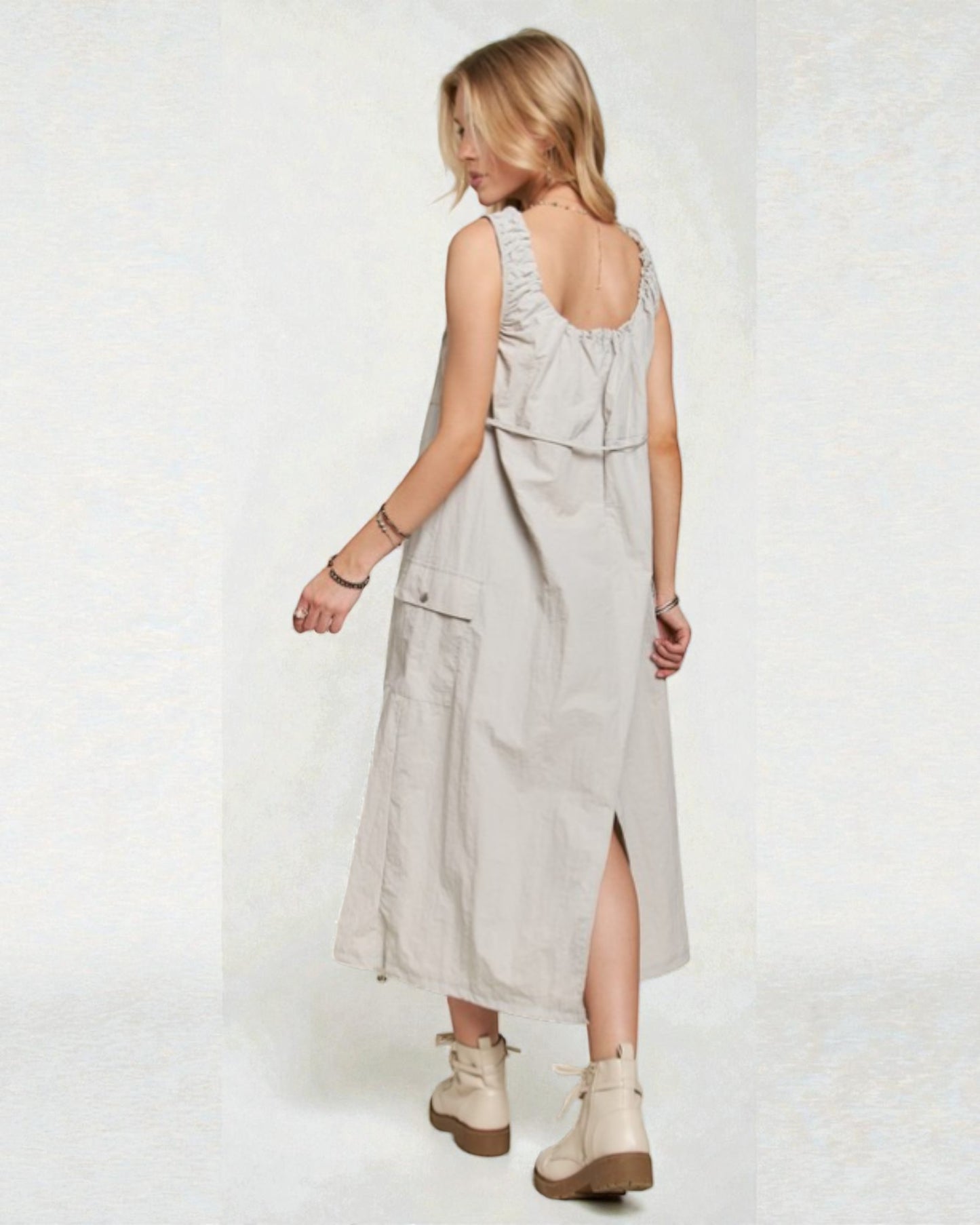 Woman wearing a light gray dress with a white background