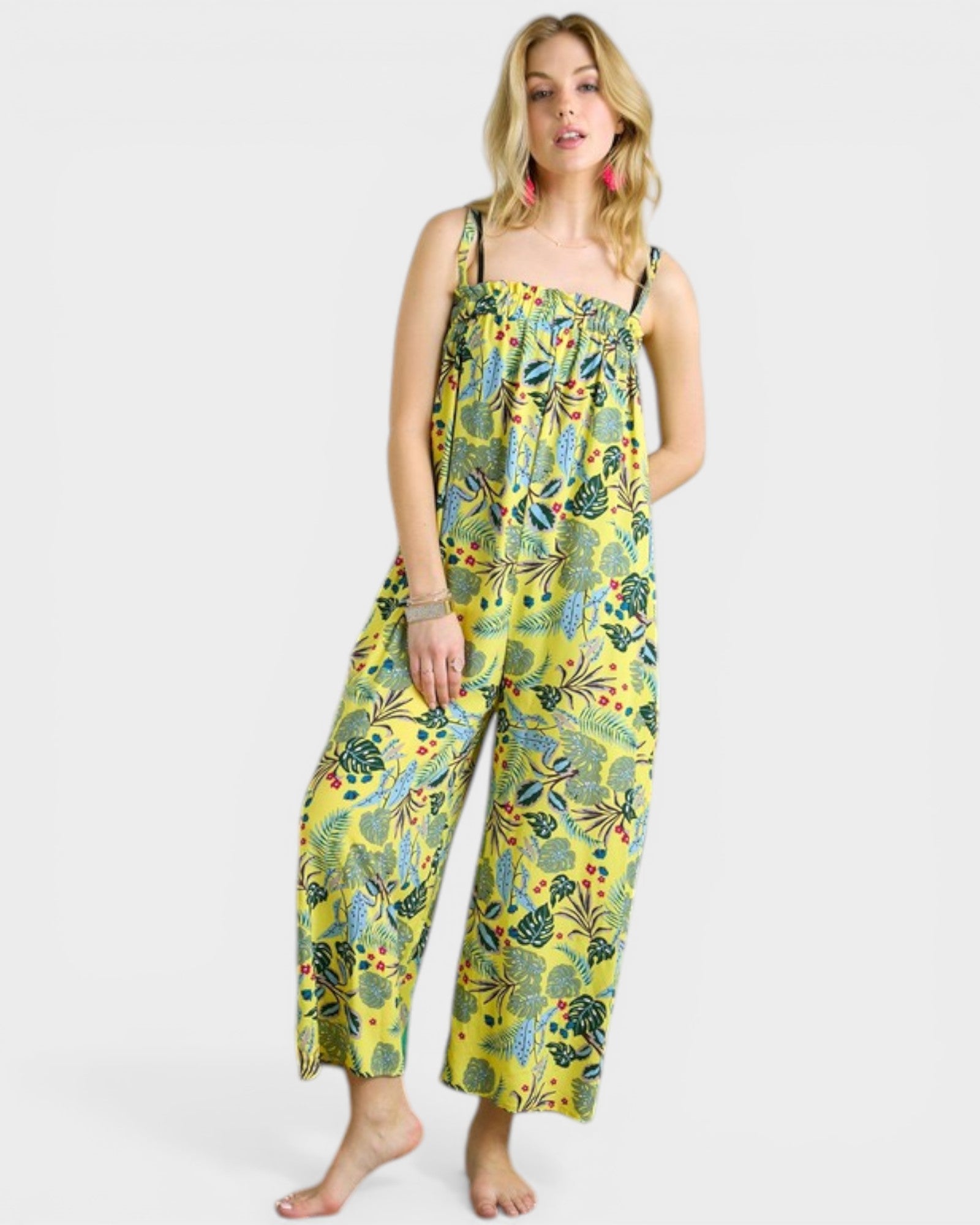 Woman wearing a yellow floral jumpsuit on a white background