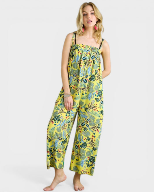 Woman wearing a yellow floral jumpsuit on a white background