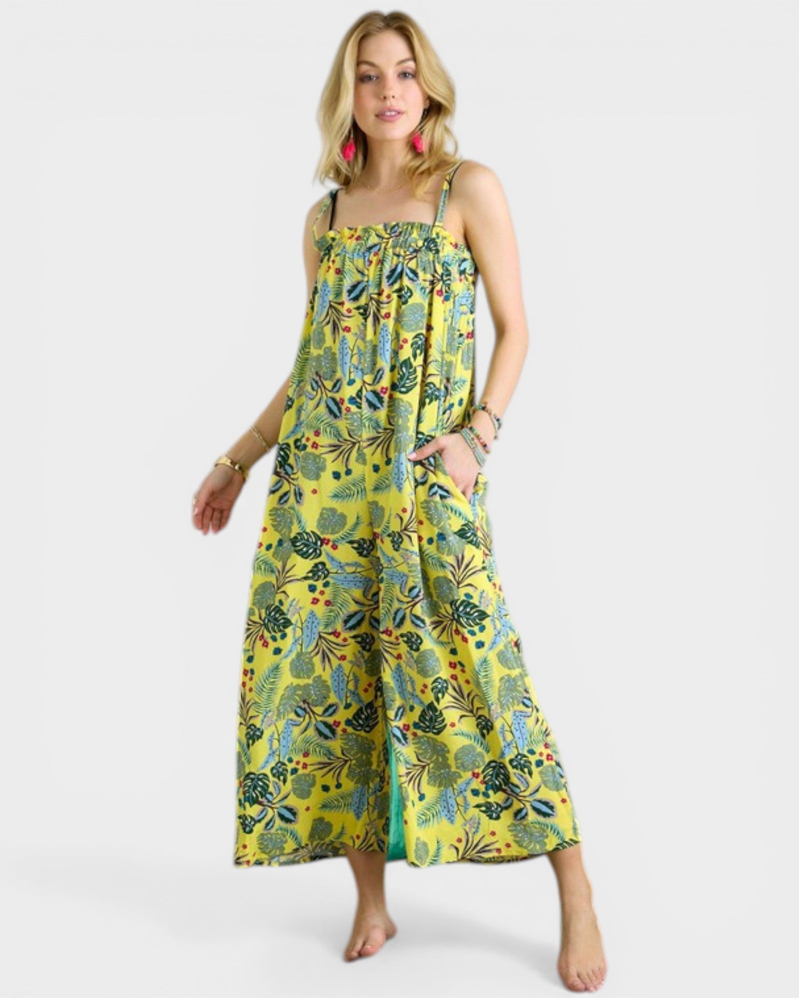 Woman wearing a yellow floral dress on a white background