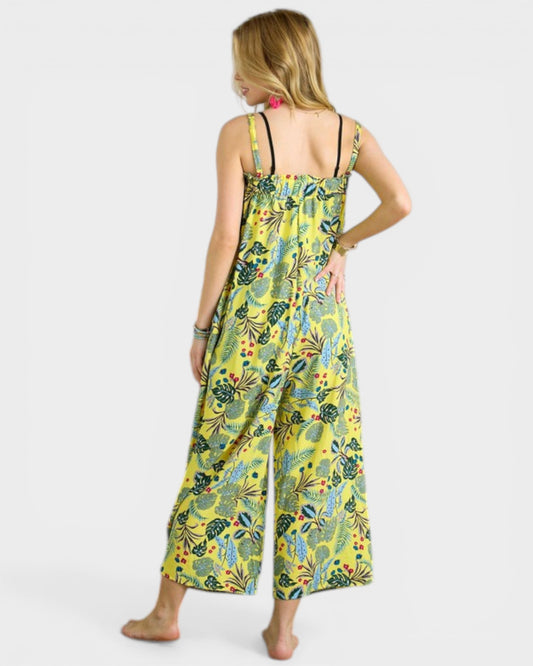 Woman wearing a yellow floral jumpsuit on a white background