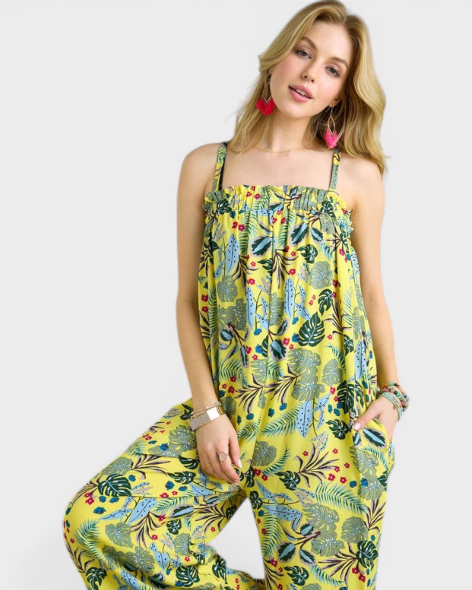 Woman wearing a yellow floral jumpsuit on a white background