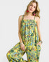 Woman wearing a yellow floral jumpsuit on a white background