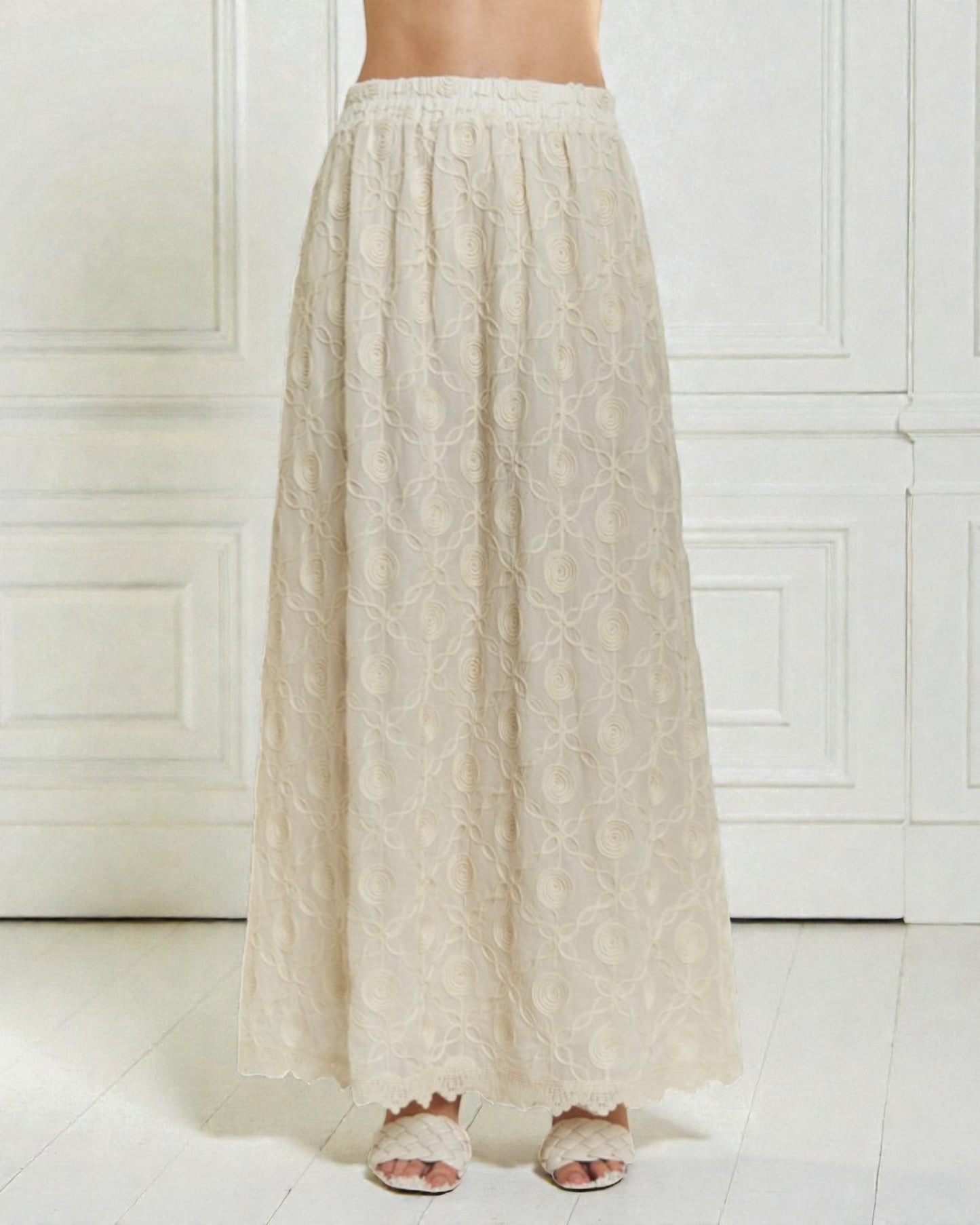 Beige lace skirt worn by a person on a white background