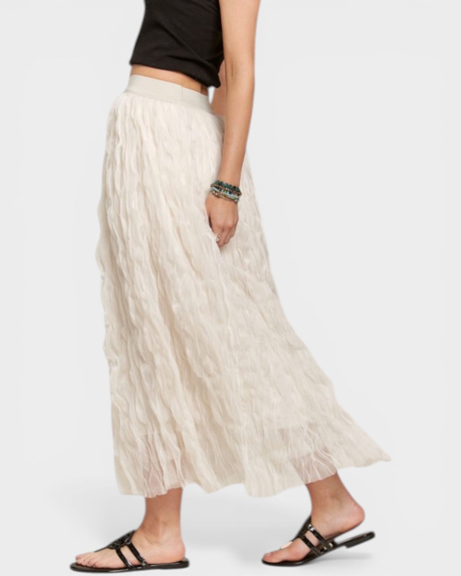 Person wearing a long beige skirt on a white background