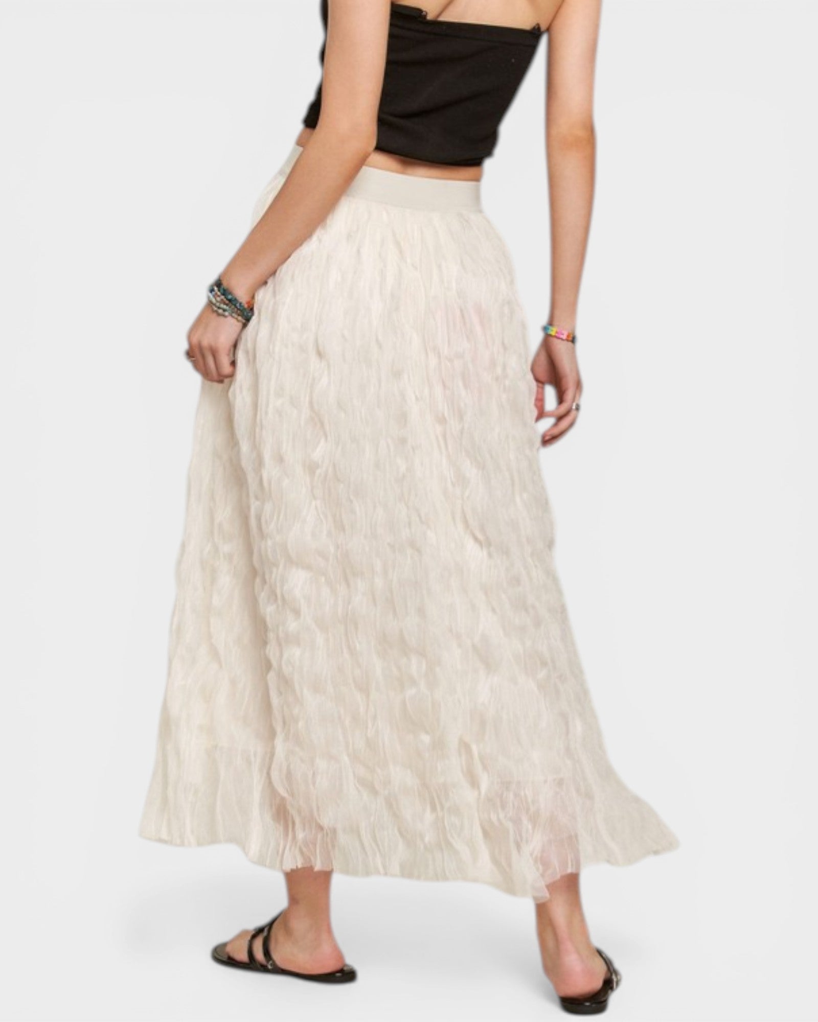 Person wearing a long beige skirt on a white background